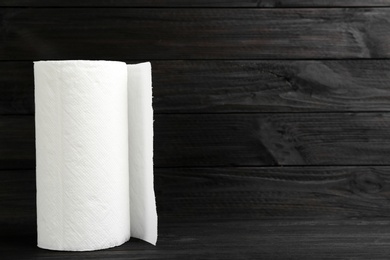 Photo of Roll of paper towels on wooden table, space for text