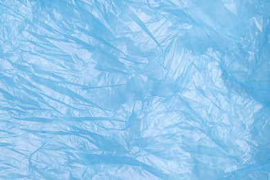 Photo of Crumpled light blue plastic bag as background, top view