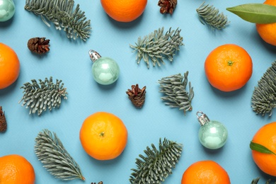 Composition with Christmas balls and tangerines on light blue background, flat lay