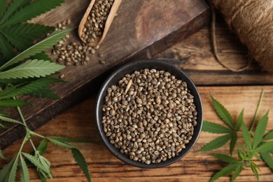 Photo of Flat lay composition with hemp seeds and leaves on wooden table