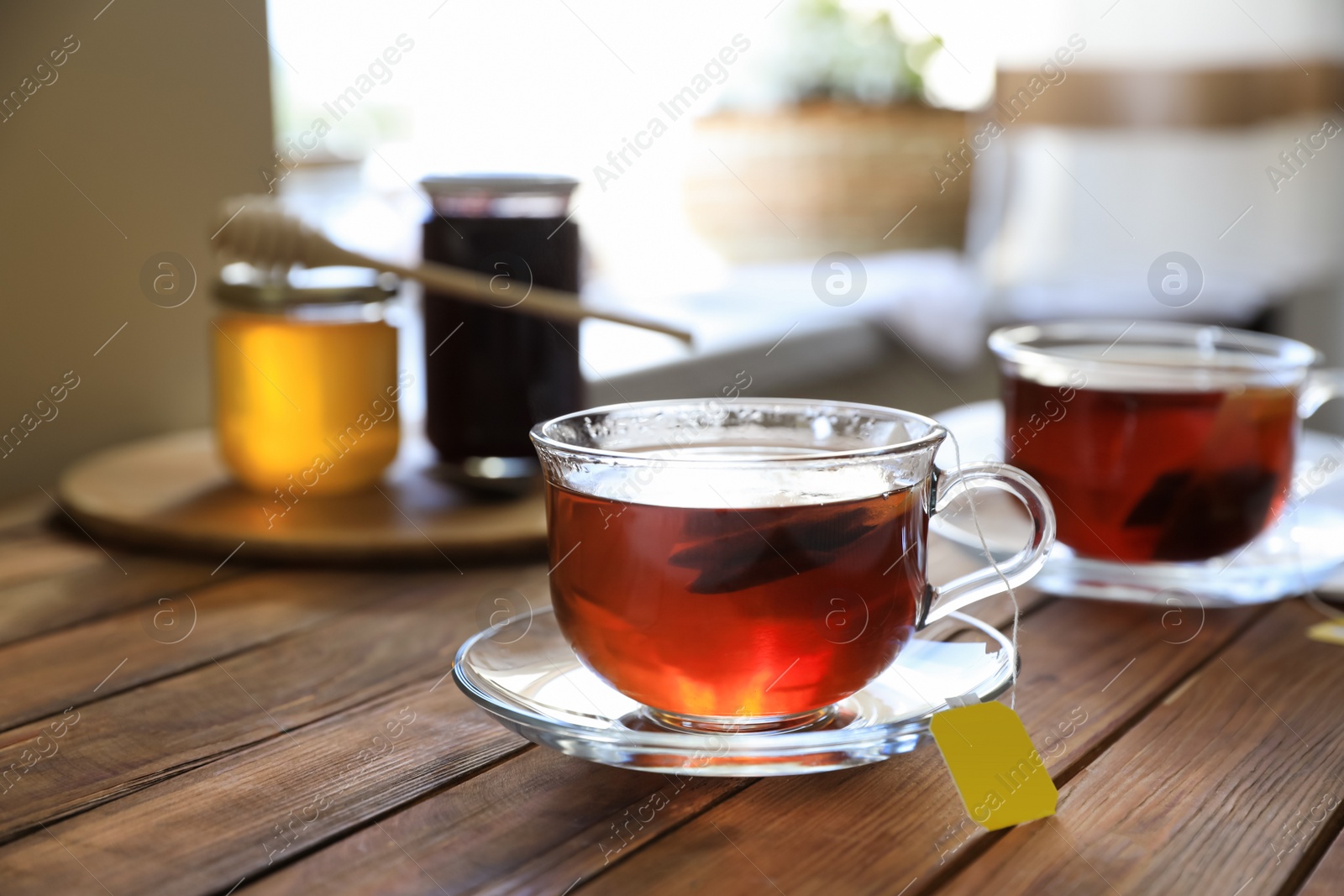 Photo of Tea bag in glass cup on wooden table indoors