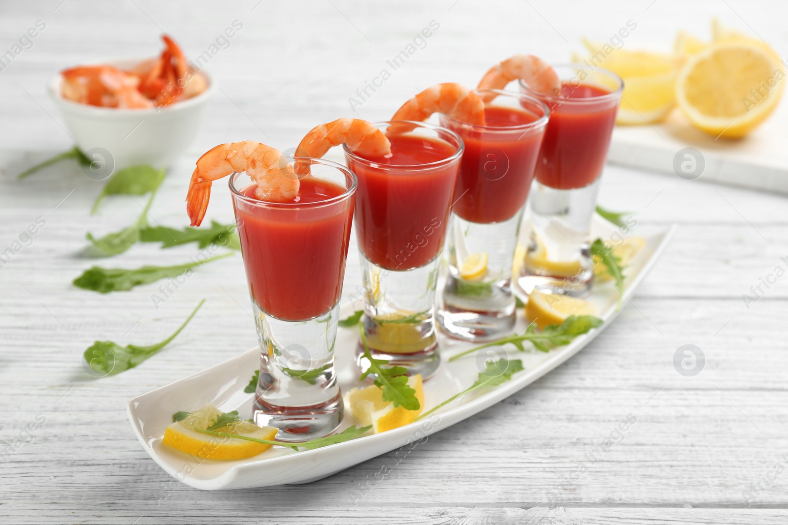 Photo of Shrimp cocktail with tomato sauce on white wooden table