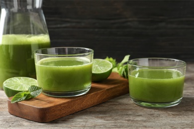 Glassware with delicious detox juice and ingredients on table