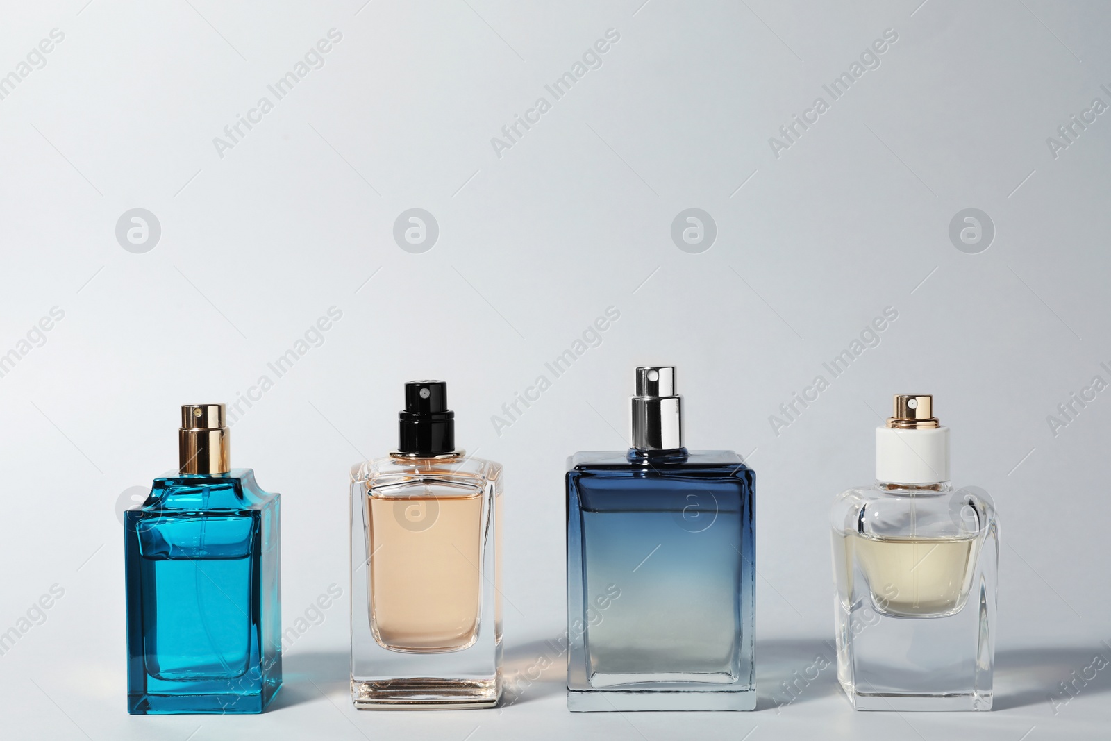 Photo of Bottles of perfume on light background