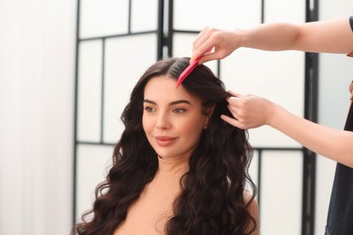 Hair styling. Professional hairdresser working with client indoors, closeup