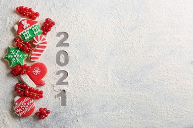 Photo of Flat lay composition with homemade Christmas cookies and number 2021 made of flour on grey table. Space for text