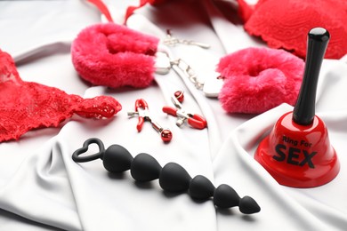 Sex toys and accessories on white fabric