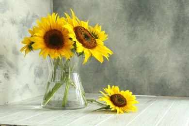 Photo of Glass vase with beautiful sunflowers and double-sided backdrops in photo studio