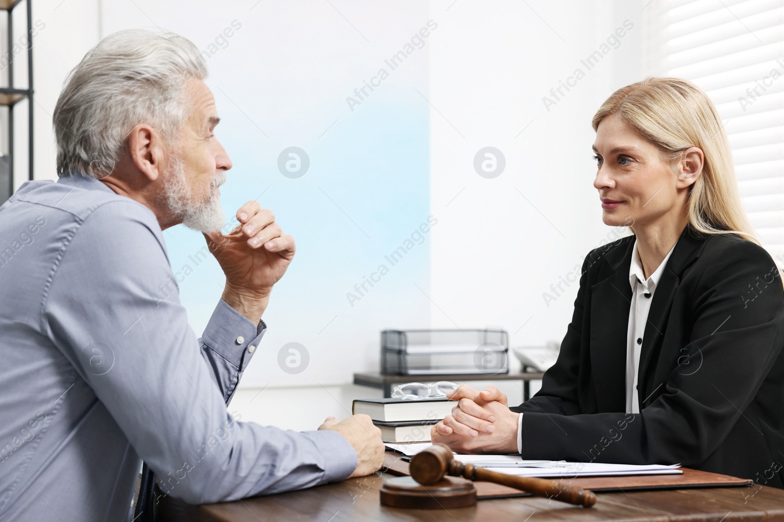 Photo of Senior man having meeting with lawyer in office