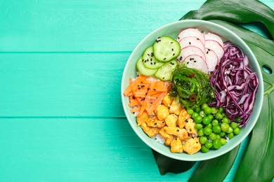 Photo of Delicious salad with chicken, vegetables and seaweed on turquoise wooden table, top view. Space for text