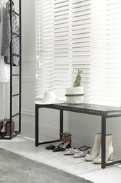 Photo of Bench with stylish women's shoes near window in dressing room. Interior design