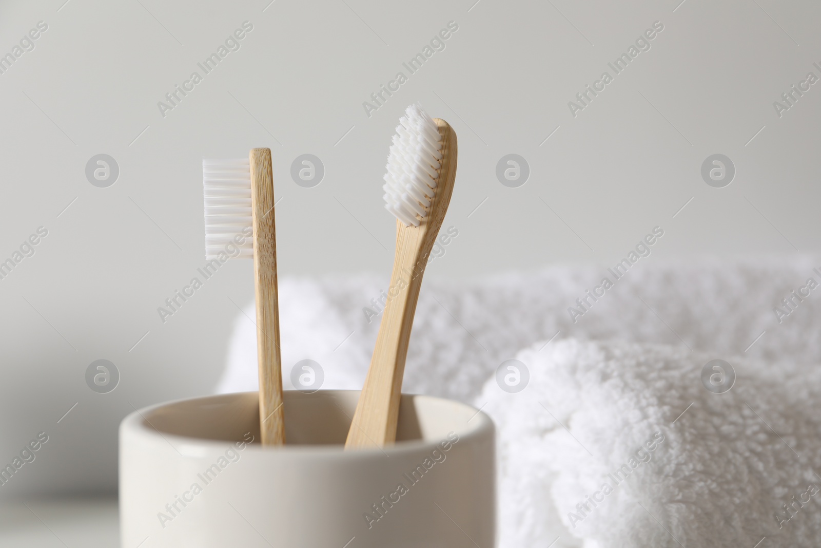 Photo of Holder with bamboo toothbrushes on blurred background, closeup. Space for text