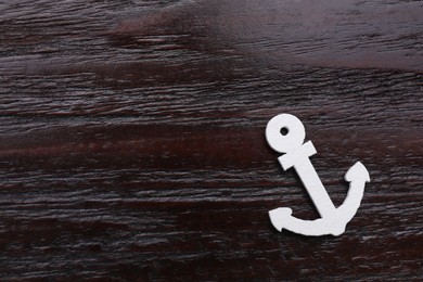 Photo of Anchor figure on dark wooden table, top view. Space for text