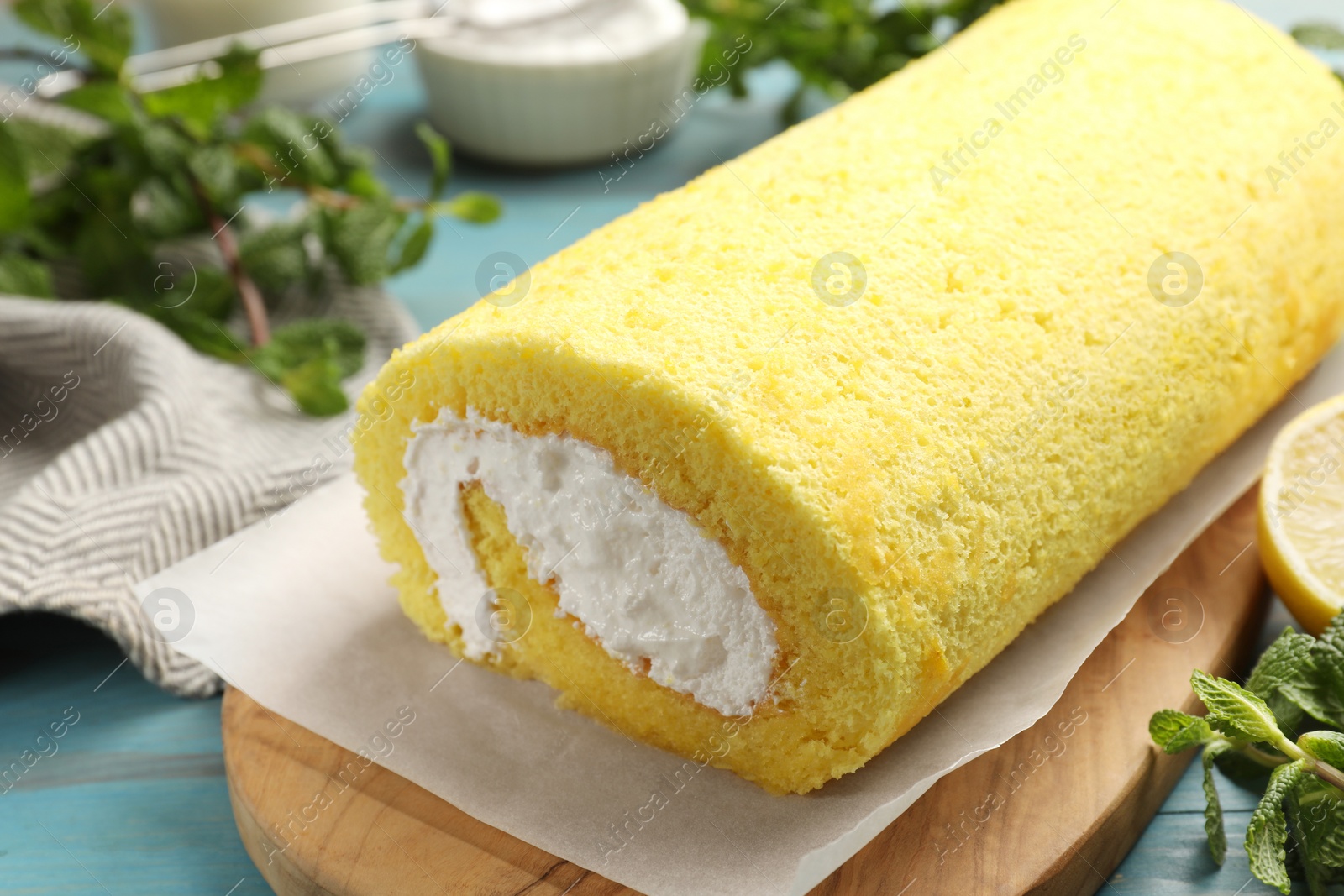 Photo of Delicious cake roll and mint on table, closeup