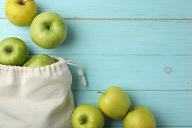 Photo of Cotton eco bag with apples on light blue wooden background, flat lay. Space for text