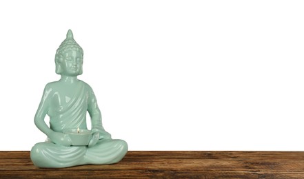 Photo of Beautiful ceramic Buddha sculpture with burning candle on wooden table against grey background. Space for text