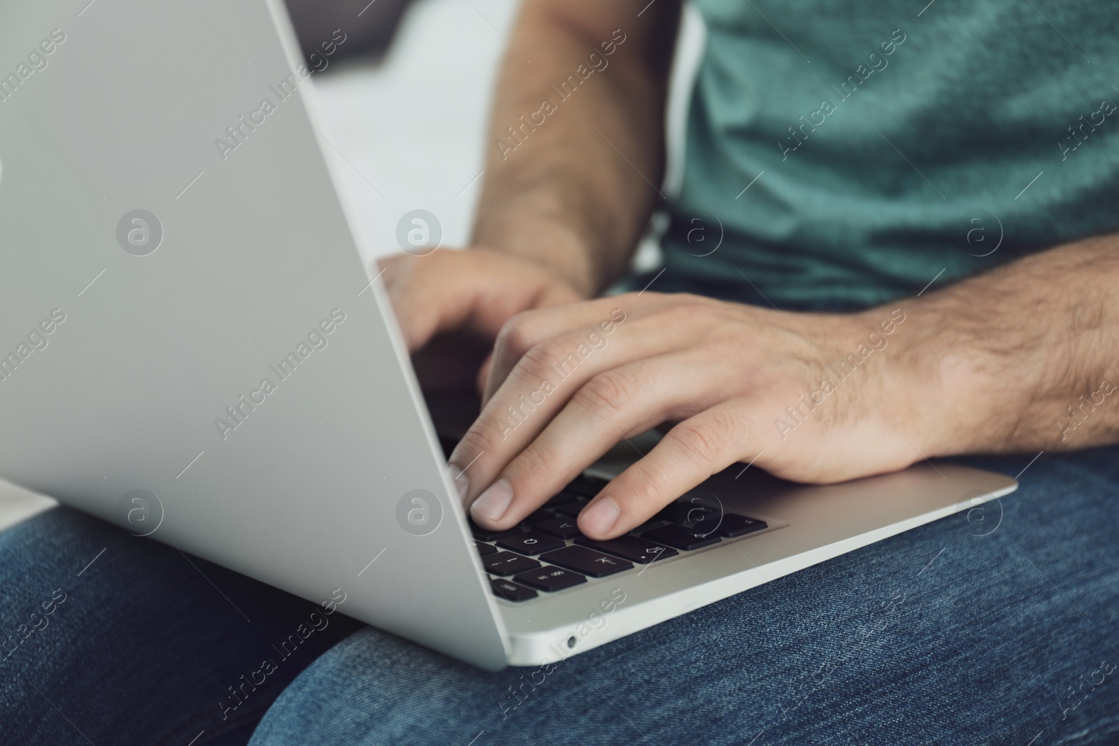 Photo of Man working on modern laptop at home, closeup