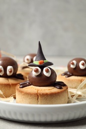 Photo of Delicious biscuits with chocolate spiders in tray, closeup. Halloween celebration