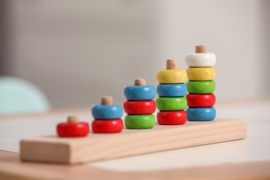 Photo of Stacking and counting game wooden pieces on table indoors. Educational toy for motor skills development