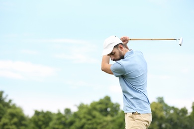 Photo of Man playing golf against blue sky. Space for text