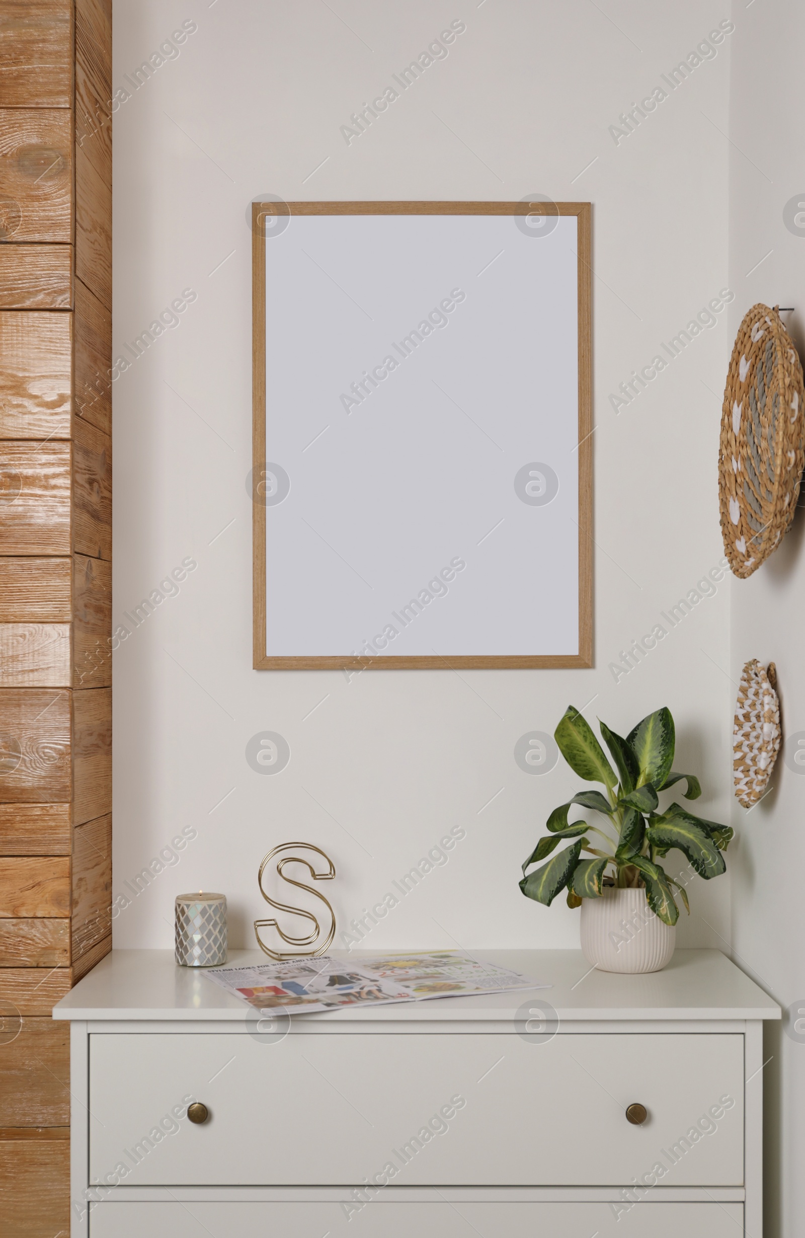 Photo of Blank frame hanging on light wall indoors. Space for design