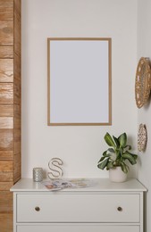 Blank frame hanging on light wall indoors. Space for design