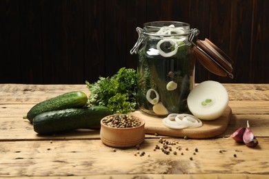 Photo of Pickling jar with fresh ripe cucumbers and spices on wooden table