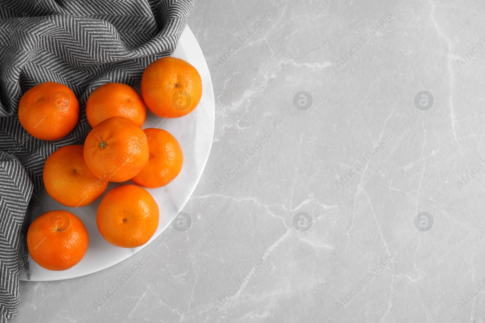 Photo of Fresh ripe tangerines on light grey table, top view. Space for text