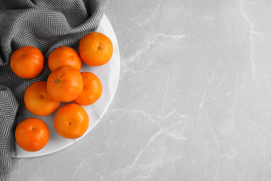 Fresh ripe tangerines on light grey table, top view. Space for text