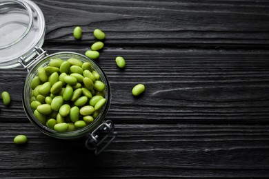 Photo of Jar of edamame beans on black wooden table, flat lay. Space for text