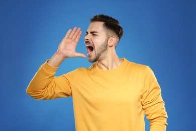 Photo of Emotional young man in stylish clothes on color background