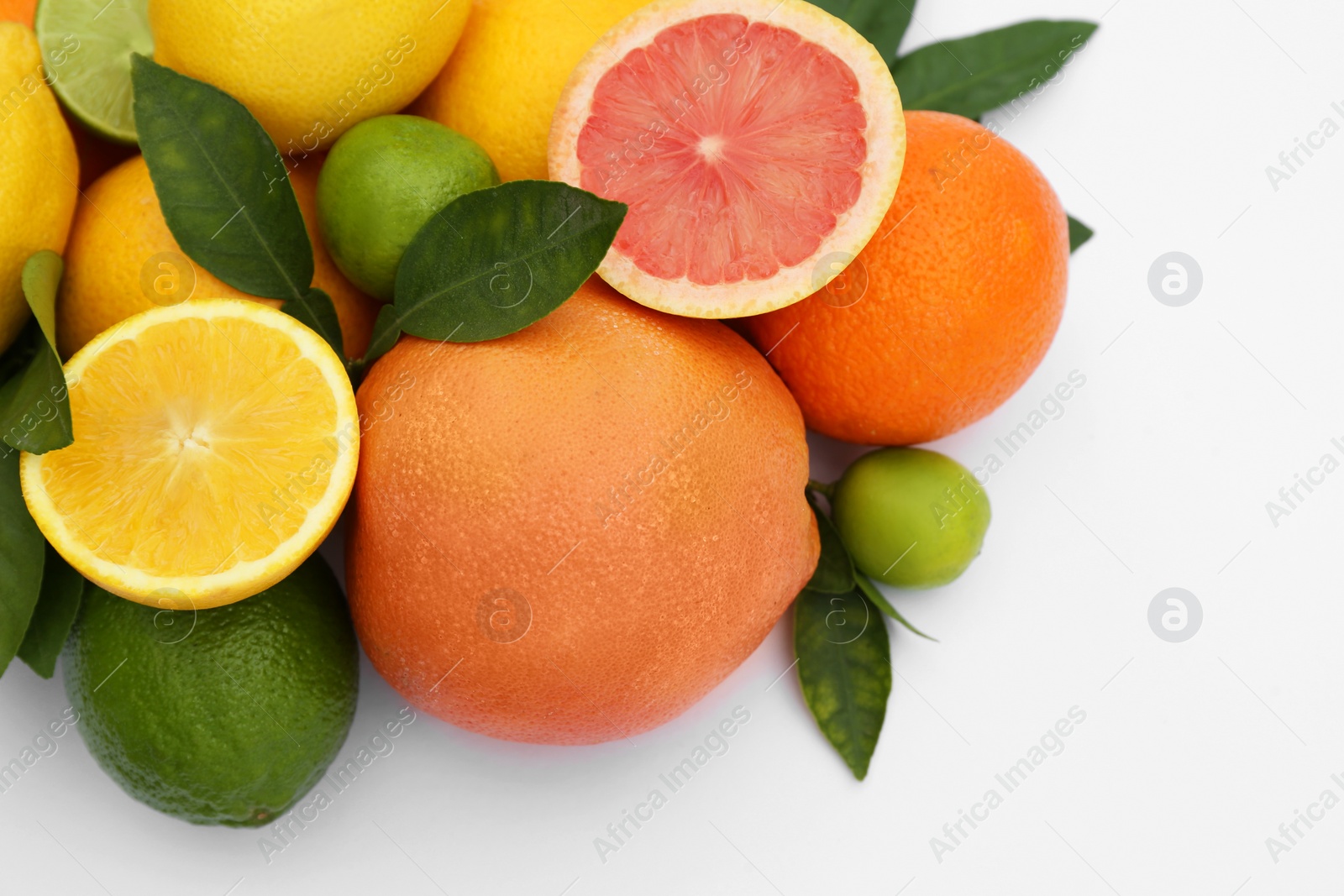 Photo of Different citrus fruits and leaves on white background, closeup