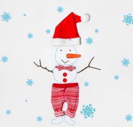 Image of Snowman with Santa hat, bow tie and small pants on white background, flat lay