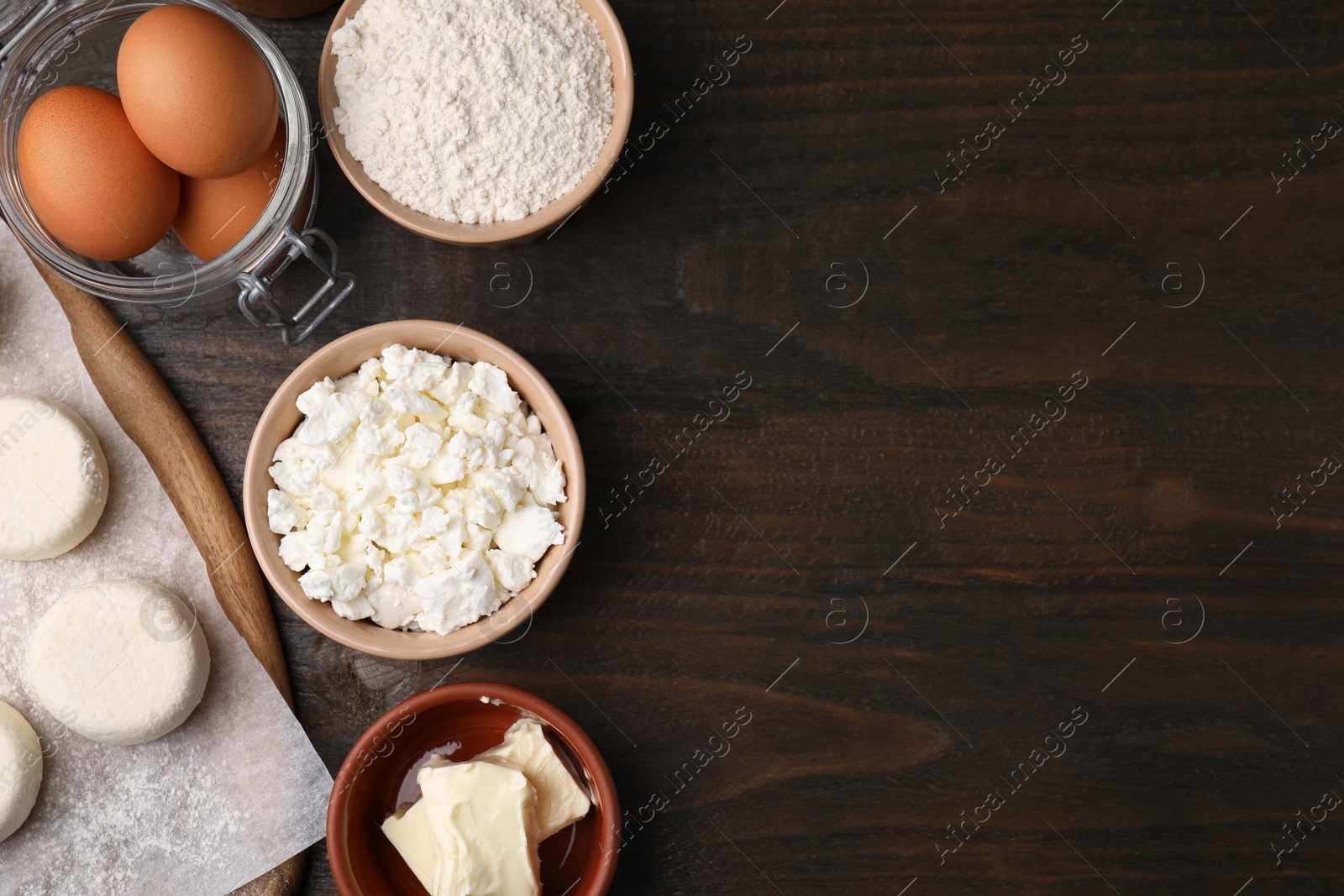 Photo of Different ingredients on wooden table, flat lay and space for text. Cooking cottage cheese pancakes