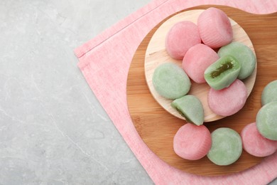 Photo of Many different delicious mochi on grey table, top view with space for text. Traditional Japanese dessert