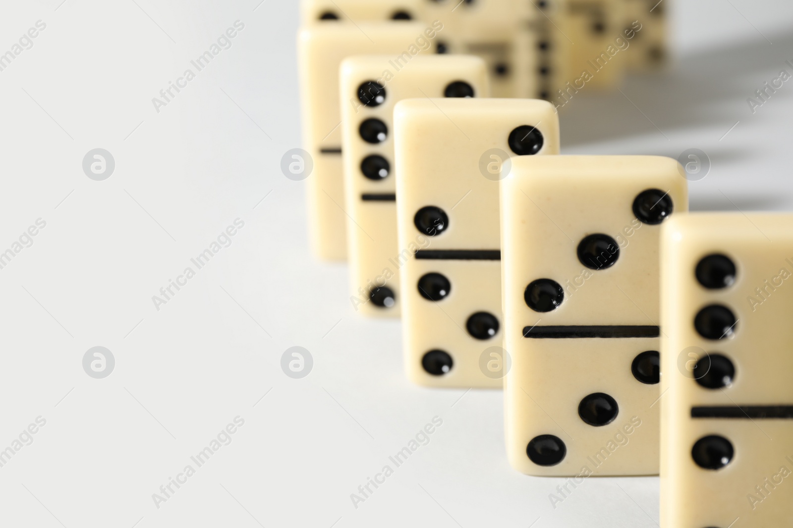 Photo of Domino tiles on white background, closeup. Space for text