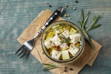 Photo of Flat lay composition with pickled feta cheese in jar on blue wooden table