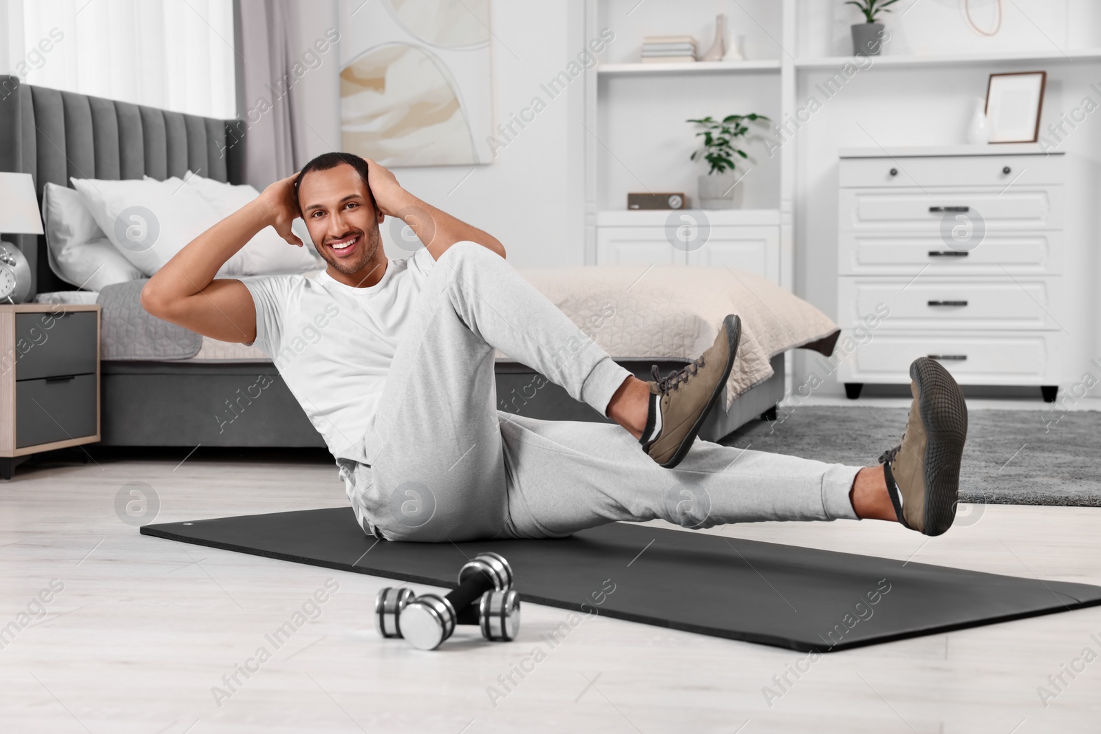 Photo of Man doing morning exercise on fitness mat at home