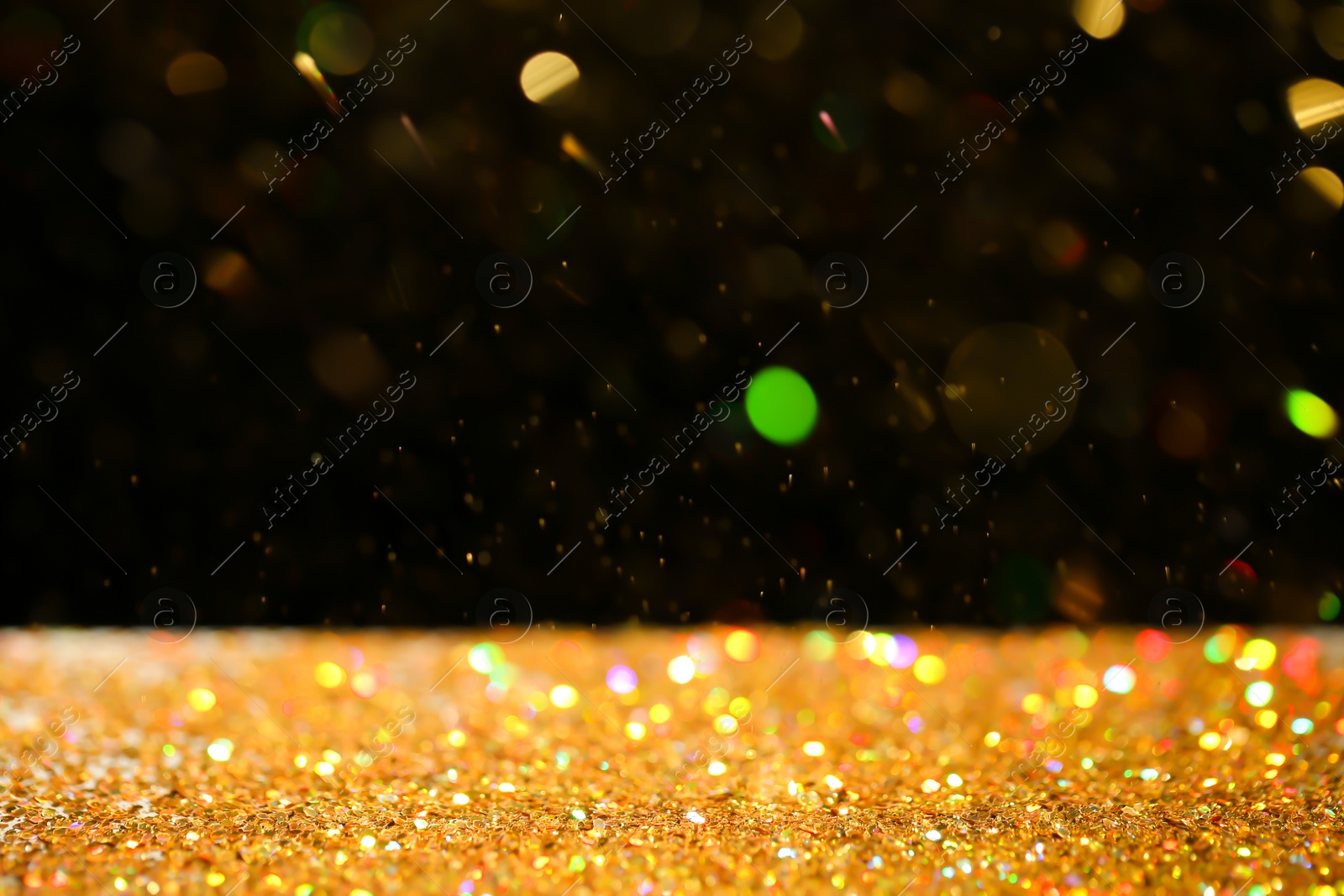 Photo of Many golden paillettes against black background. Space for text