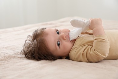 Photo of Cute little baby with toy on bed