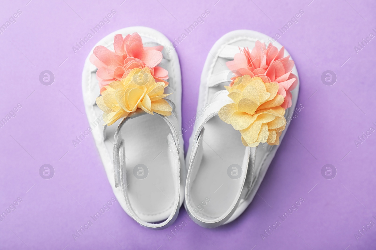 Photo of Pair of cute baby sandals on color background, top view