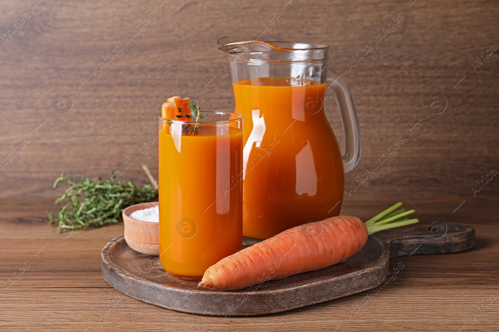 Photo of Freshly made carrot juice on wooden table