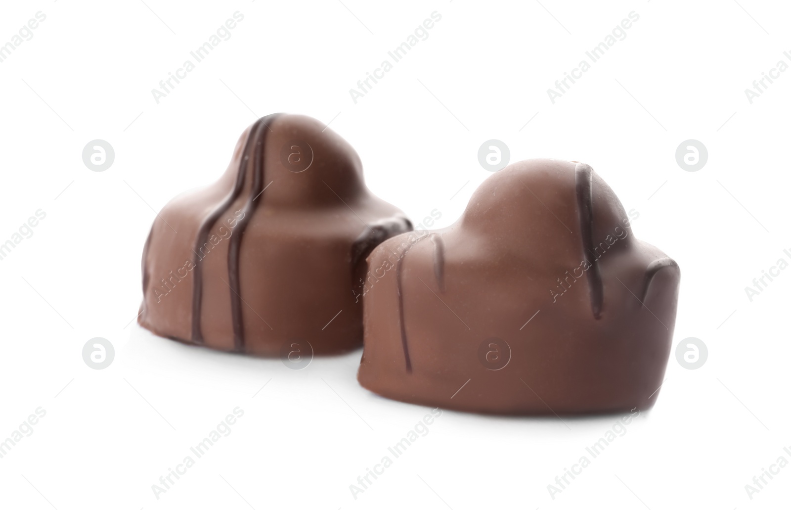 Photo of Delicious milk chocolate candies with nuts isolated on white