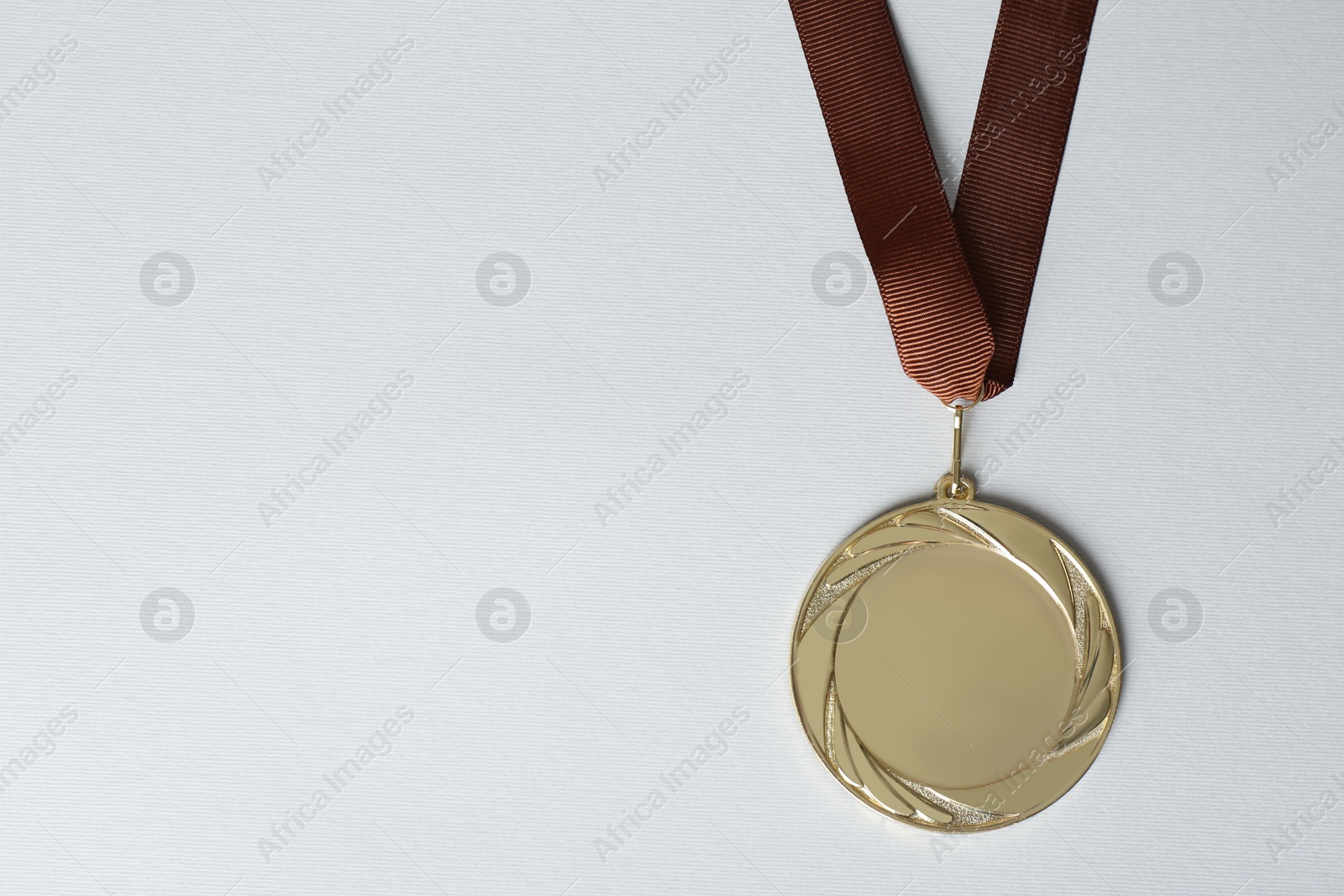 Photo of Gold medal on white background, top view. Space for design