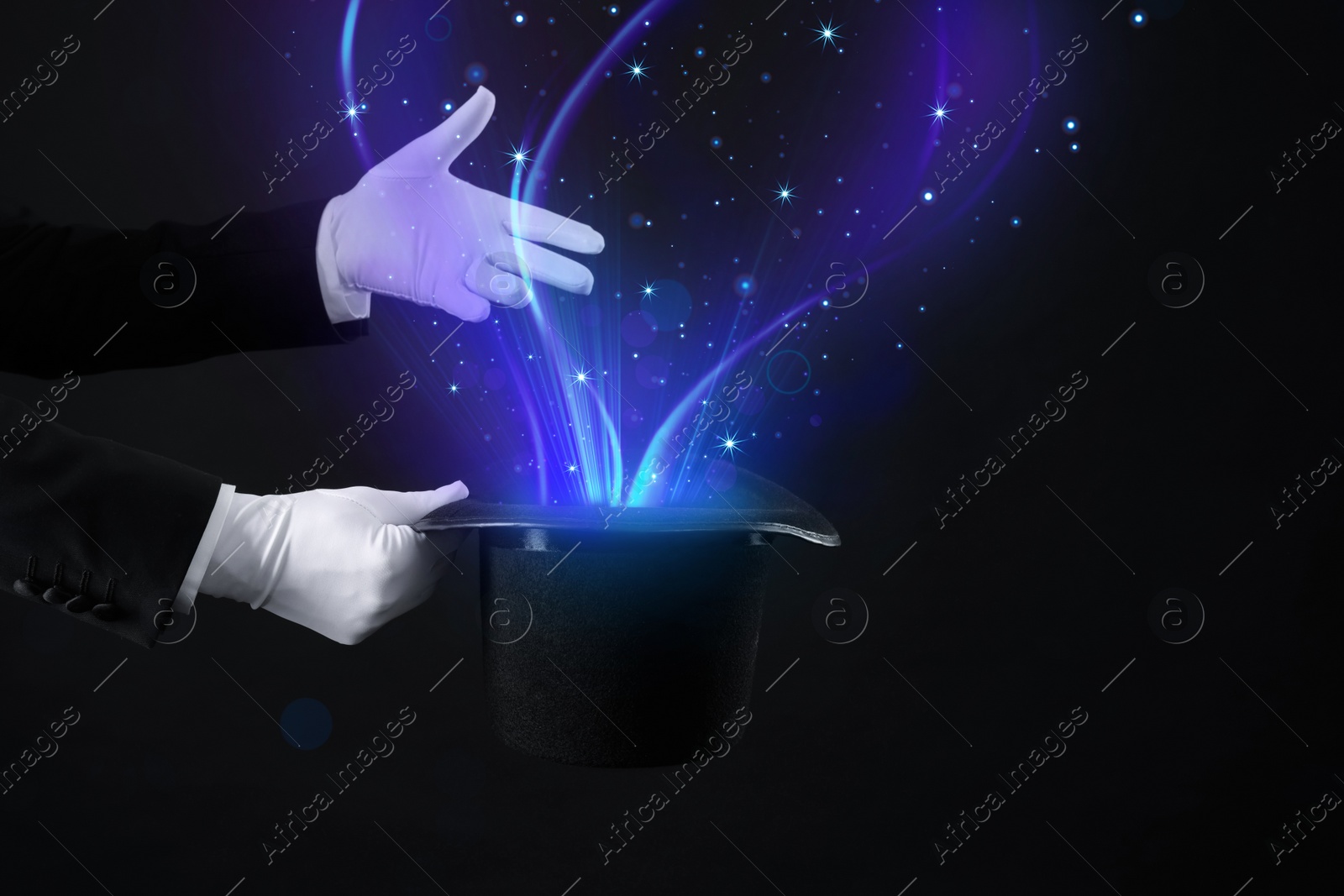 Image of Magician showing trick with top hat on black background, closeup