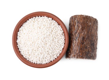 Tapioca pearls in bowl and cassava root isolated on white, top view