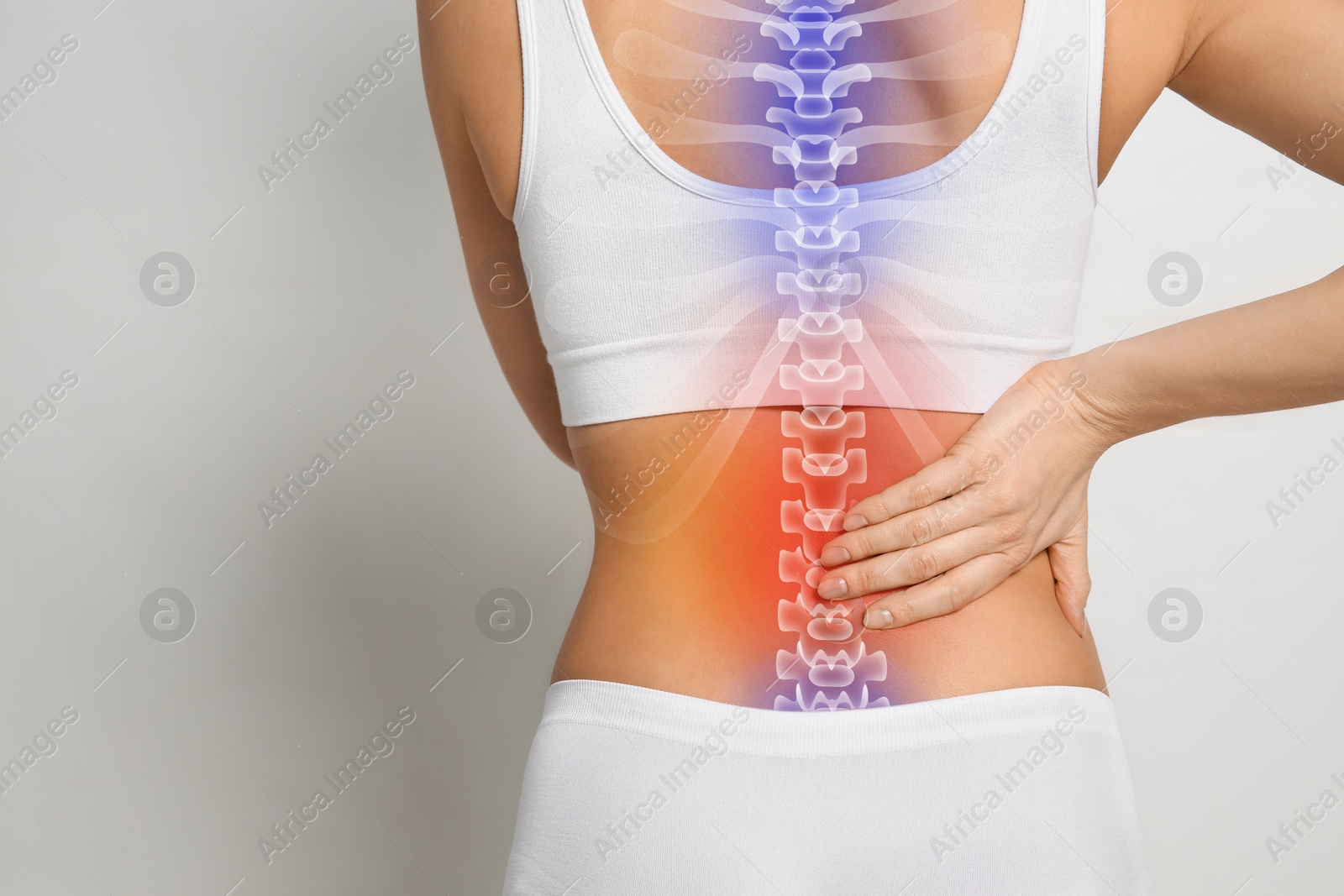 Image of Woman suffering from pain in back on light grey background, closeup. Space for text