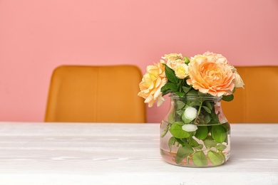 Photo of Vase with blooming flowers on table indoors