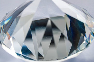 Photo of Beautiful dazzling diamond on light grey background, closeup. Precious gemstone