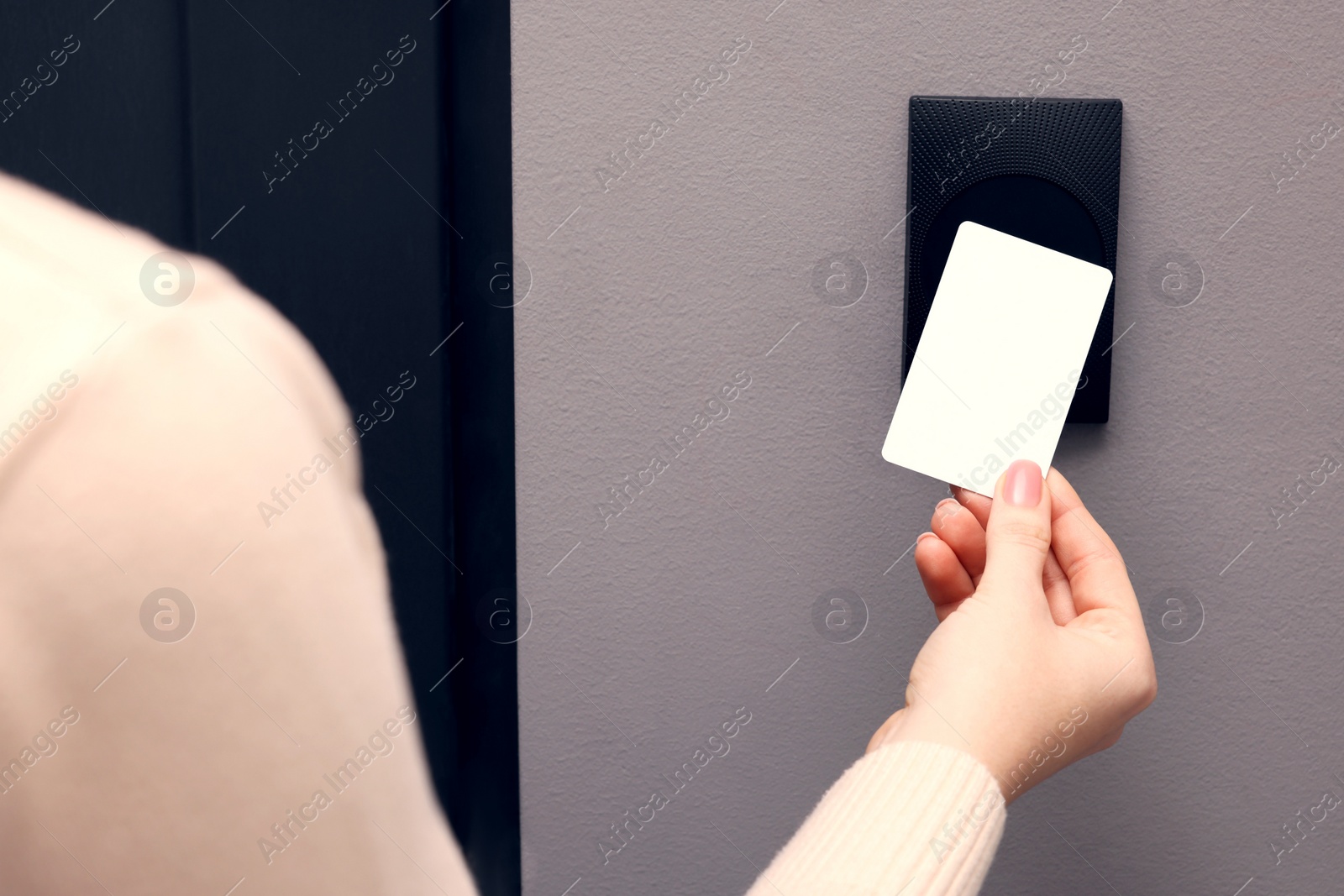 Photo of Woman opening magnetic door lock with key card, closeup. Home security